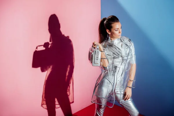 Beautiful Woman Metallic Bodysuit Raincoat Posing Boombox Pink Blue Background — Free Stock Photo