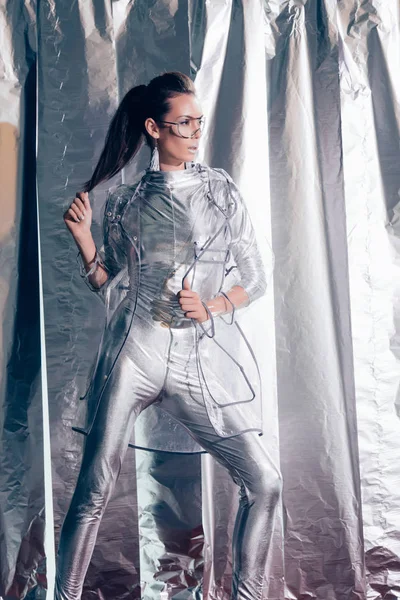 Beautiful Young Model Posing Silver Bodysuit Raincoat Metallic Background — Free Stock Photo