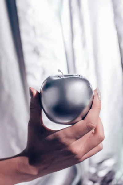 Kırpılan Gümüş Elma Metalik Arka Plan Üzerinde Elinde Tutan Kız — Stok fotoğraf