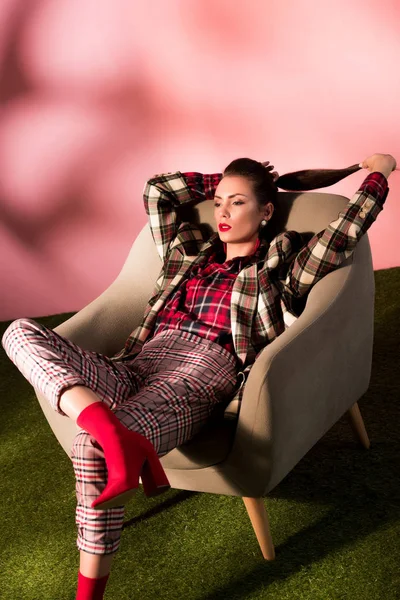 Hermosa Mujer Con Estilo Traje Cuadros Posando Sillón Sobre Fondo — Foto de stock gratuita