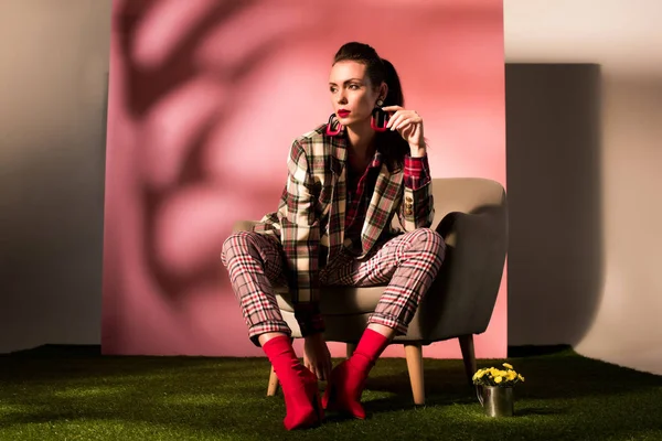 Atractiva Chica Elegante Traje Cuadros Posando Sillón Sobre Fondo Rosa — Foto de Stock