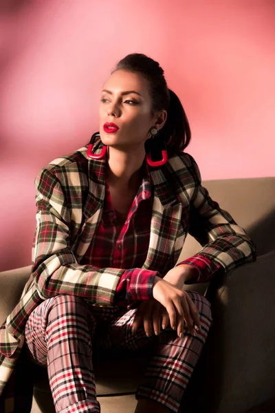 Schöne Stilvolle Mädchen Karierten Anzug Posiert Sessel Auf Rosa Hintergrund — Stockfoto