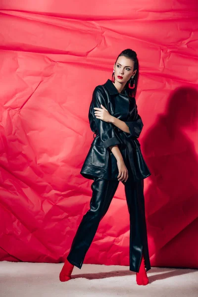 Красива Модна Жінка Позує Чорному Шкіряному Костюмі Червоному Тлі — Безкоштовне стокове фото