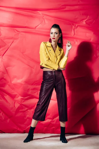 Modelo Morena Moda Posando Chaqueta Cuero Amarillo Sobre Fondo Rojo — Foto de Stock