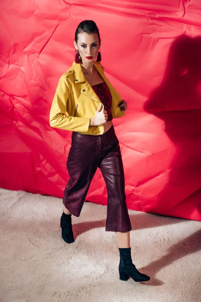 Modelo Elegante Posando Chaqueta Cuero Amarillo Sobre Fondo Rojo Para — Foto de Stock