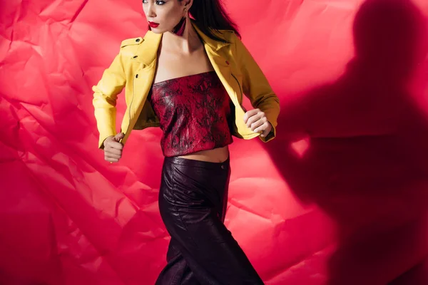 Atraente Mulher Elegante Posando Jaqueta Couro Amarelo Fundo Vermelho — Fotos gratuitas