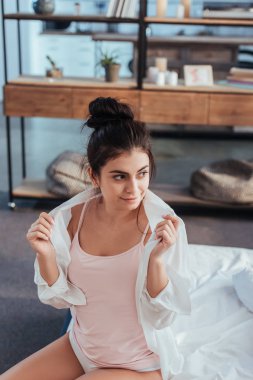 evde sabah zaman sırasında beyaz forması koyarak neşeli genç kadın