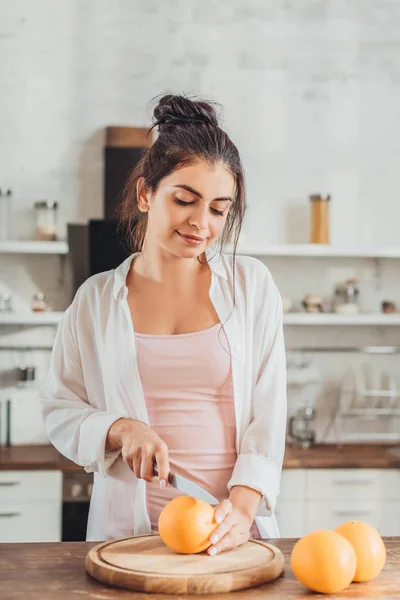 Jovem Mulher Cortando Laranja Por Faca Placa Madeira Cozinha — Fotos gratuitas