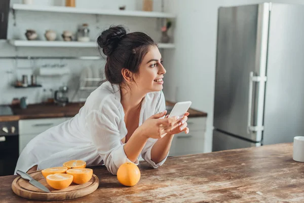 Allegra Giovane Donna Utilizzando Smartphone Tavolo Legno Con Arance Cucina — Foto Stock