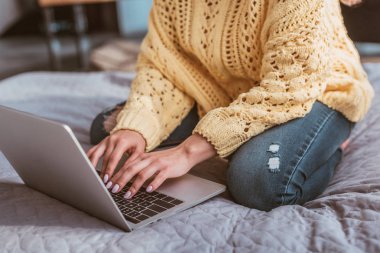 evde yatakta otururken dizüstü bilgisayarda çalışan kadın Freelancer kısmi görünümü