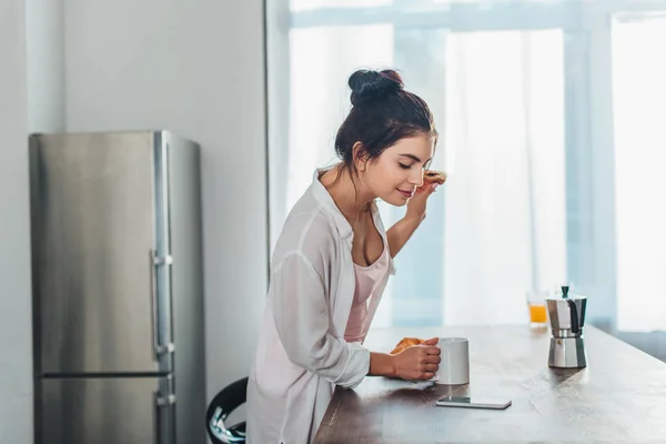 Sidovy Tjej Att Frukost Och Kontroll Smartphone Nära Träbord Köket — Stockfoto