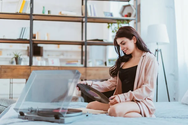 Menina Segurando Vinil Registro Perto Fonógrafo Sentado Cama Casa — Fotografia de Stock