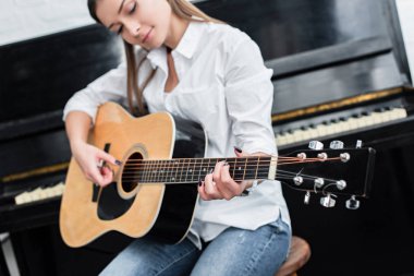 oturma ve gitar oturma odasında piyano ile arka planda çalmaya kız