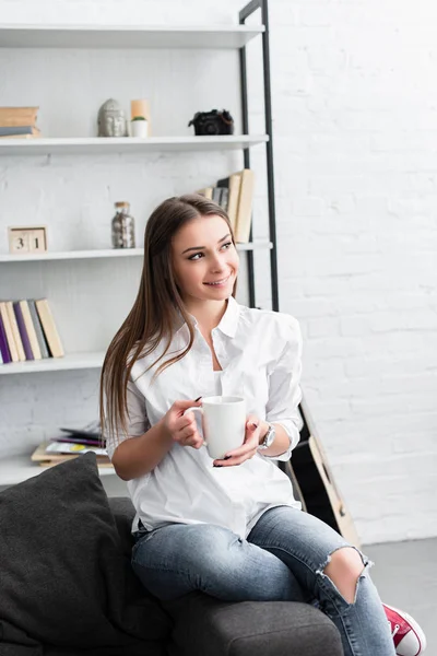 Gülümseyen Kız Ile Kahve Fincanı Oturma Odasında Kanepede Oturan — Stok fotoğraf