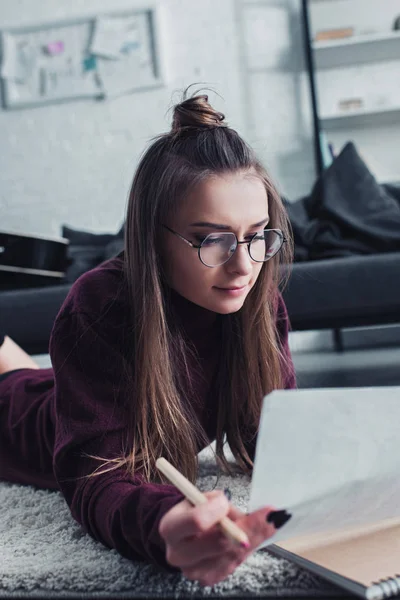 Attraktive Designerin Liegt Auf Teppich Und Hält Bleistift Und Skizze — Stockfoto