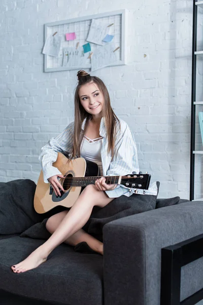 Sonriente Músico Sentado Sofá Tocando Guitarra Acústica Casa — Foto de Stock