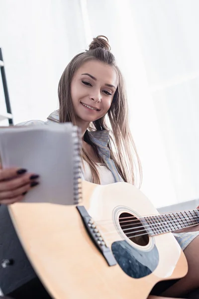 Smiling Musician Holding Notebook Acoustic Guitar Home — Stock Photo, Image