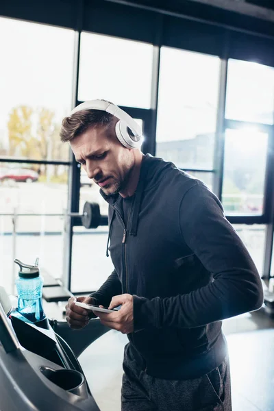 Handsome Sportsman Hoodie Exercising Treadmill Using Smartphone Gym — Free Stock Photo