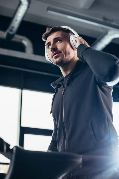 Low Angle View Handsome Sportsman Hoodie Exercising Treadmill Listening Music — Free Stock Photo