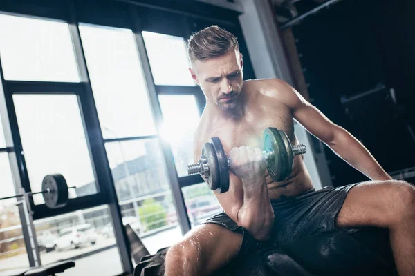 Apuesto Deportista Musculoso Sentado Neumático Haciendo Ejercicio Con Mancuerna Gimnasio — Foto de Stock