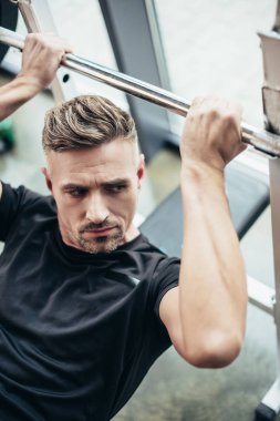 Halter salonunda kaldırmak için yakışıklı sporcu bankta yalan yüksek açılı görünüş
