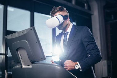 takım elbise ve spor salonunda treadmill egzersiz sanal gerçeklik kulaklık işadamı düşük açılı görünüş