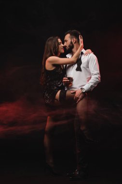 tutkulu kadın viski cam adam kırmızı dumanlı odada sarılma 