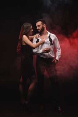 tutkulu kadın viski cam adam kırmızı dumanlı odada sarılma 