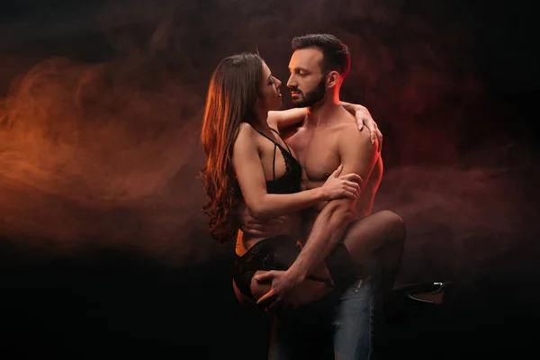 passionate couple hugging in smoky room