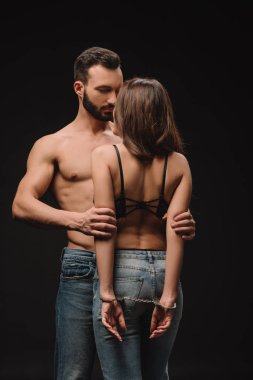 yakışıklı gömleksiz adam kucaklama şehvetli kız siyah izole kelepçeli