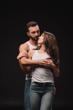Beyaz singlet siyah izole yakışıklı adam kucaklama genç kadında