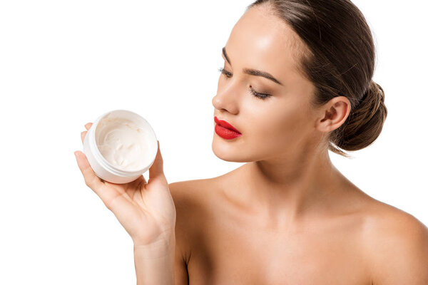 attractive girl with red lips looking at jar with face cream isolated on white