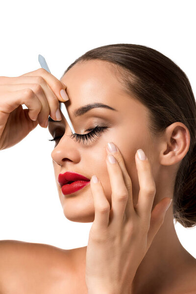 close up view of beautiful girl keeping false eyelashes with tweezers isolated on white