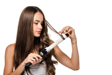 beautiful girl with long brown hair using curling iron isolated on white clipart
