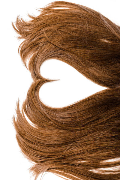 cropped view of long brown female hair in shape of heart isolated on white