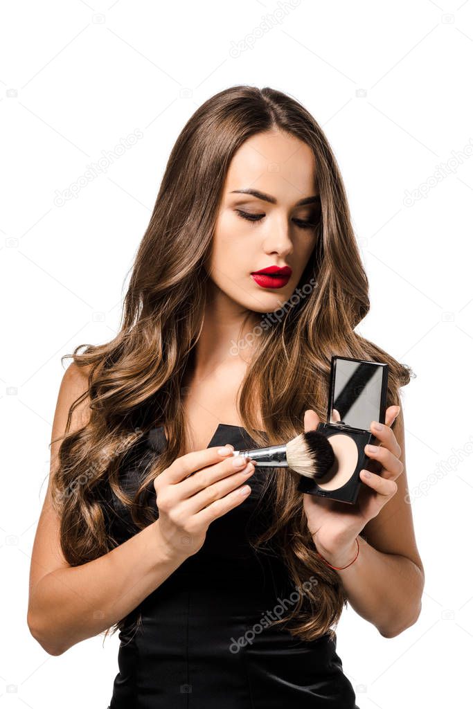 attractive girl in black dress with red lips holding powder and cosmetic brush isolated on white