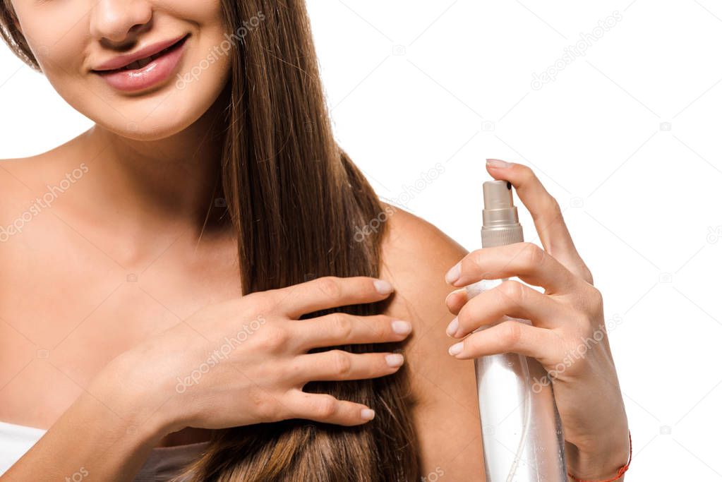 cropped view of smiling girl using hair spray isolated on white