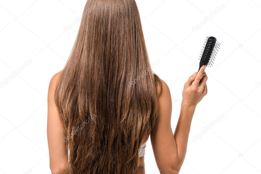 back view of girl with long brown hair holding hairbrush isolated on white