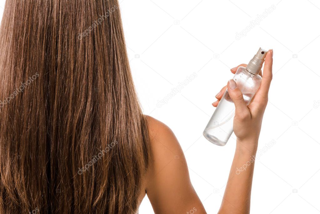 back view of girl with long brown hair holding hair spray isolated on white