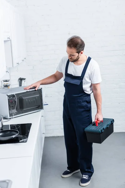 Hoge Hoekmening Van Volwassen Klusjesman Met Toolbox Controleren Magnetron Keuken — Stockfoto