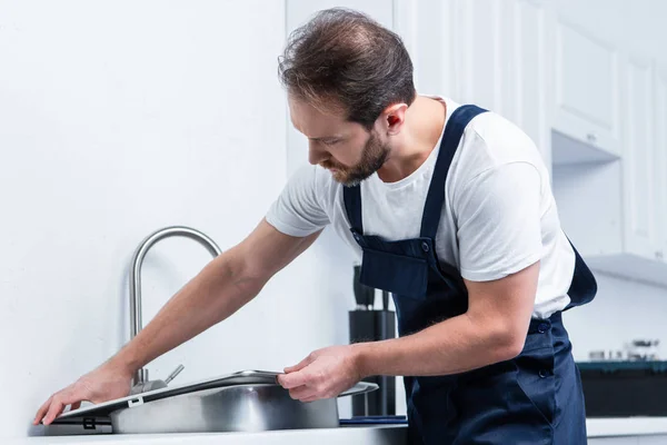 Ενηλίκων Γενειοφόρος Επισκευαστής Εργάζονται Συνολικά Στερέωσης Νεροχύτη Στην Κουζίνα — Φωτογραφία Αρχείου