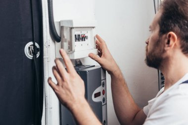 Erkek sakallı el işleri ustası elektrik kutusu denetimi yan görünüm 