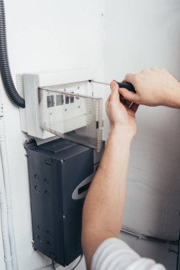 Erkek elektrikçi elektrik kutusu tornavida tarafından tamir kısmi görünümü 