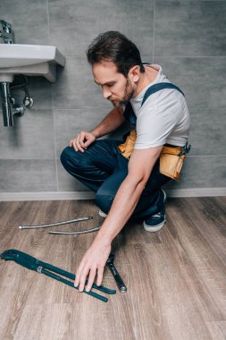 banyo lavabo kırık onarmak için gaz anahtarı alarak yetişkin erkek tesisatçı 