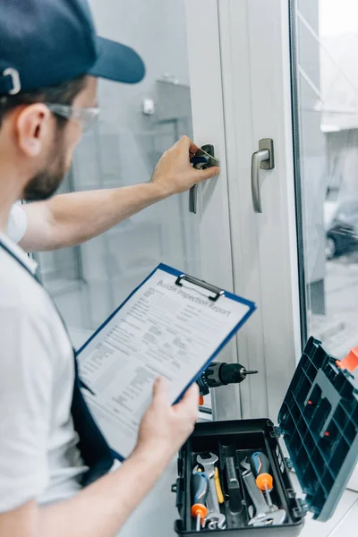 Gedeeltelijke Weergave Van Klusjesman Bril Klembord Houden Controleren Van Vensteringang — Stockfoto