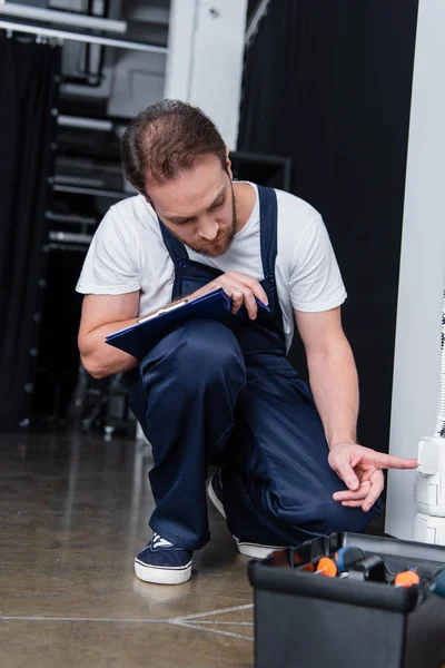 Erwachsener Männlicher Elektriker Mit Klemmbrett Steckdose — Stockfoto