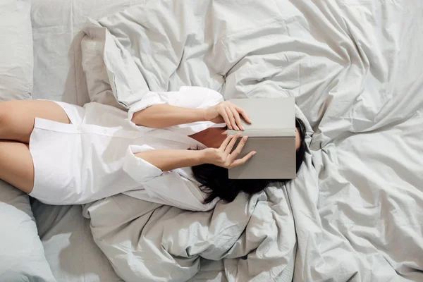 Вид Зверху Молоду Жінку Білій Сорочці Лежить Книгою Обличчі Ліжку — стокове фото