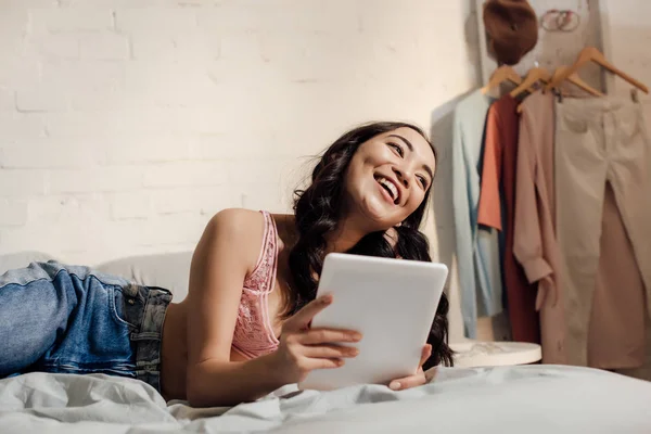 Szczęśliwa Młoda Kobieta Azjatyckich Leżąc Łóżku Przy Użyciu Komputera Typu — Zdjęcie stockowe