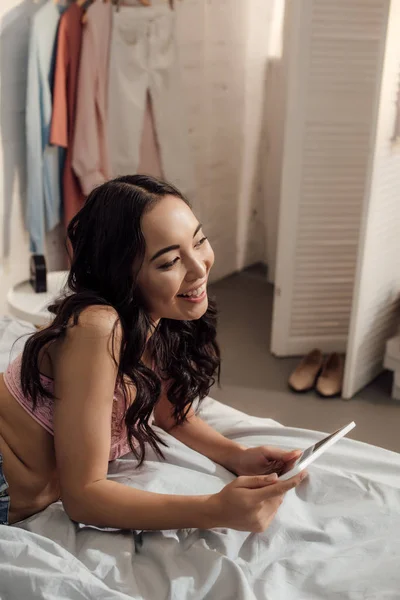 Красивая Улыбающаяся Азиатская Девушка Лежит Кровати Использует Цифровой Планшет — стоковое фото