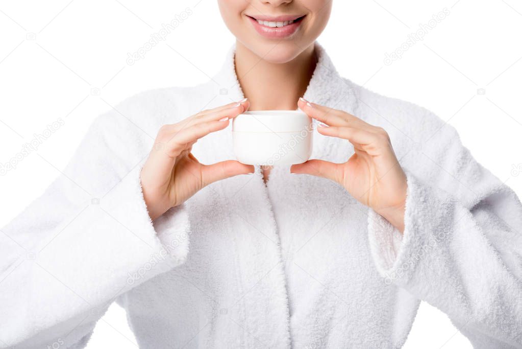 cropped view of woman in bathrobe holding face cream isolated on white